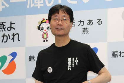 越後くがみ山酒呑童子行列のオリジナルTシャツを着て記者会見を行う鈴木燕市長
