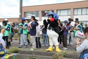 農業体験田「スワローズ・ライスファーム」で行われたツアー客との稲刈りで稲刈りを応援するつば九郎