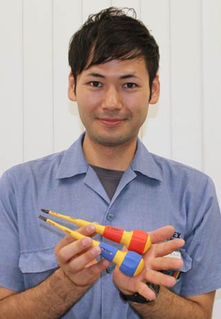 グッドデザインベスト100に選ばれたスリム絶縁ドライバーを手に兼古常務