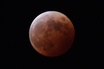  食がほぼ最大となった7時55分、赤銅色に染まった満月