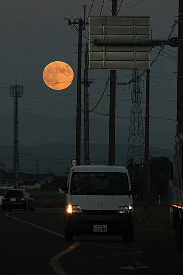 日没とともに昇り始めた満月を燕市内から