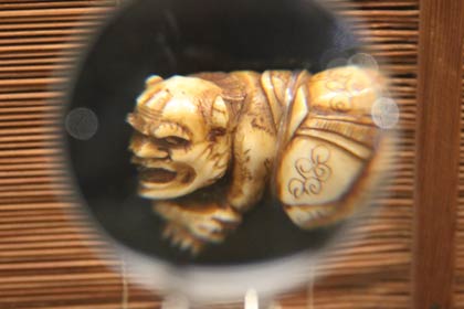 切られた腕を押さえる茨木童子を表現した帯留め