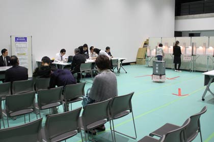 午後7時前、仕事帰りに投票する人が立ち寄る