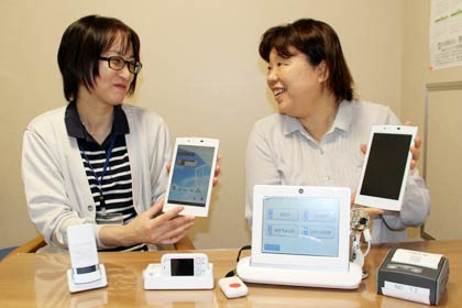 定期巡回・随時対応型訪問介護看護事業を開始した社会福祉法人吉田福祉会の荒川秀子ひまわりの園センター長(左)と佐々木晴美ホームヘルプサービスひまわりの園管理者、手にしているのは利用者と連絡をとるタブレットなどの端末