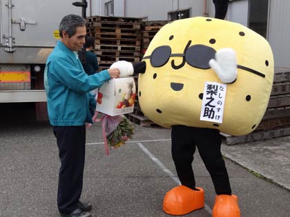 「なんかん育ち」ゆるきゃらマスコット『梨之助』さんからトラックの運転主に「新高」を手渡す