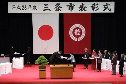 被表彰者一人ひとりに表彰状を手渡す