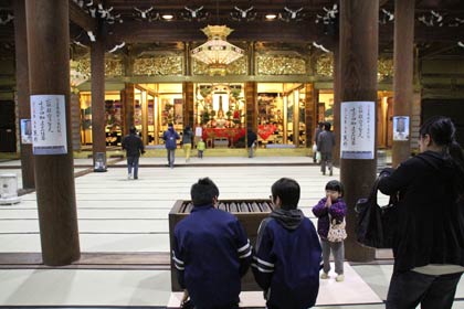  修復の終わった本堂を見学する参拝者