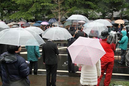 雨のなかで支持者が演説に聴き入る