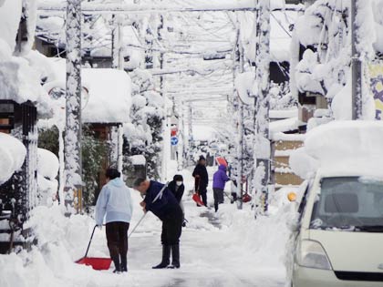 14日朝、三条市横町で雪かきする市民