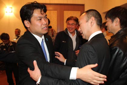  握手したり抱き合ったりして支持者らの支援に感謝する鷲尾氏