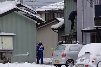 17日昼の三条市鶴田3の火災現場、中央に写る規制線の先に全焼したアパートがある
