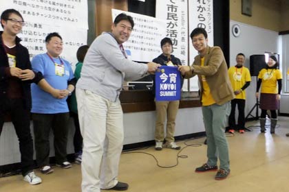  11月に富岡市で開かれた今宵サミットでペナントを受け取る“つばめ若者会議”の平出明彦リーダー(左側)