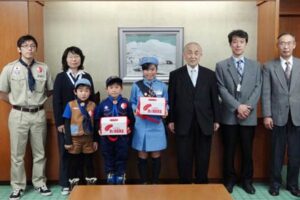 街頭募金に寄せられた善意を歳末たすけあい募金に寄付した日本ボーイスカウト加茂第1団とガールスカウト新潟県第30団、新潟県加茂市支会会長の小池加茂市長らと記念写真