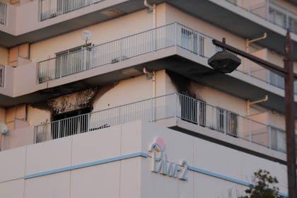 火災から一夜明けた28日のパルムマンションは、火事のあった部屋の窓の外が黒くなっている以外は火災のつめあとは見当たらない