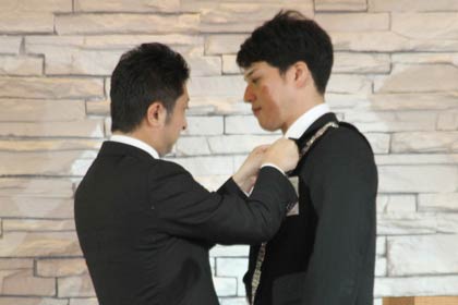 1月例会で加藤直前理事長から理事長バッジを石黒理事長へ