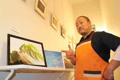 「自己満足展vol.1－写真世界－」が開かれているミニシアターカフェ「キネマ・カンテツ座」で店主の関本さんとその作品