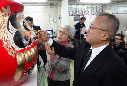 君子夫人とだるまの目入れをする小林氏