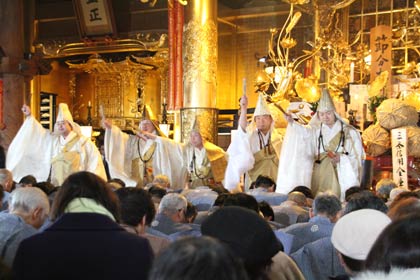 木剣を打ち鳴らして参拝者をはらい清める