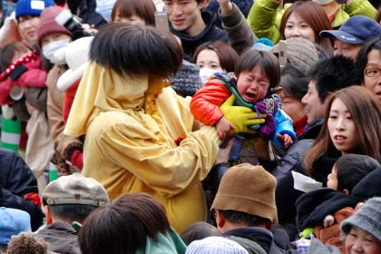 本堂で大暴れして境内を鐘楼堂へ向かう鬼に身動きできないほどの人垣