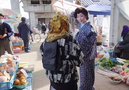 定期市の会場を歩いて出店者や買い物客とふれあう
