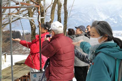 手の平にえさを載せて野鳥を待つ参加者