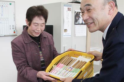 手作りの交通安全標語付きはし袋セット1,000セットを石口燕署長に手渡す燕市交通指導隊副隊長の藤節子さん
