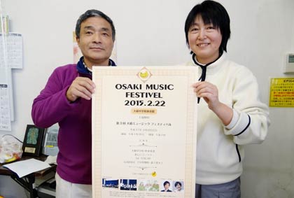 22日に大崎中体育館で開く第3回大崎ミュージックフェスティバルのポスターを手に来場を呼びかける大崎コミュニティのメンバー