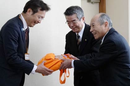 国定市長(左)にAEDを手渡す三条中央ライオンズクラブの外山博会長(中央)と三条ライオンズクラブの捧孝夫会長(右)