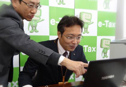 決して得意とは言えないパソコンに向かって照れくさそうに操作する国定市長