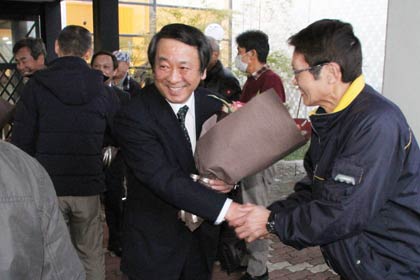 支持者らと笑顔で握手して役場をあとに
