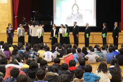 燕市立東小学校の「かけはし集会」で開かれた「かけはし集会」で『笑顔を忘れないで』を演奏する「コーロ・スプラウト」