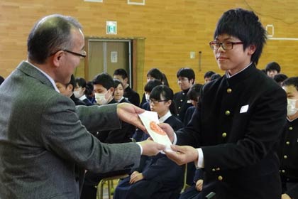 JAにいがた南蒲の相田専務理事から第四中3年生の高野さんに「難関突破米」を手渡す