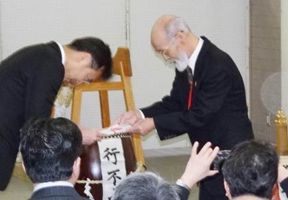 国定市長(左)に寄付した石柱の目録を手渡す佐竹さん