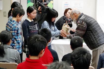 交流ルーム「ひばり」代表の佐竹さんに保内小児童から自分たちで栽培したコメのプレゼント