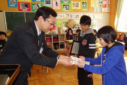  渡辺環境課長から6年生に認定証や記念品を手渡す