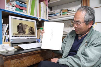 写真を寄せた渡辺隆一さん、請願書を手に