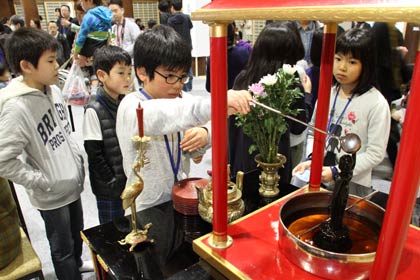 釈迦の誕生を祝って釈迦像に甘茶をかける灌仏（かんぶつ）体験