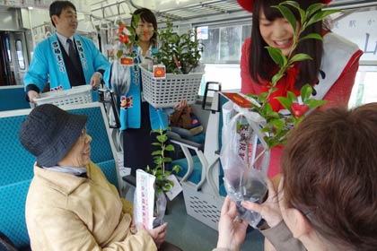 乗客にユキツバキの苗木をプレゼントして雪椿まつりをPR