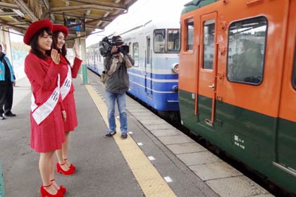手を振って列車を見送る
