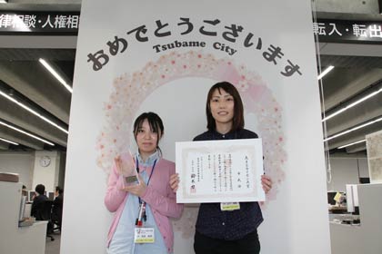 TQCカイゼン自慢大会で「花まるカイゼン大賞」を受けた市民課の職員が賞状とトロフィーを手に