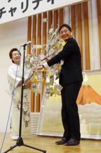 国定市長にまゆ玉に下がった善意と半藤政衛さんが描いた赤冨士を寄付するスナックマンマの五十嵐敏江さん