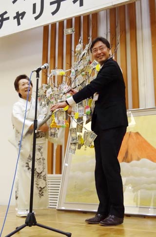 国定市長にまゆ玉に下がった善意と半藤政衛さんが描いた赤冨士を寄付するスナックマンマの五十嵐敏江さん