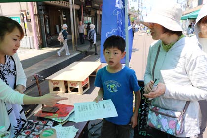 「まちなかクエスト」で「勇者の書」を手に三条マルシェ会場で回答を探す