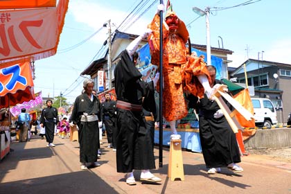 八幡宮を背に進む大名行列のてんぐ