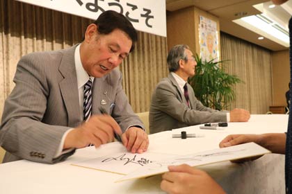 ファンにこたえてサインする