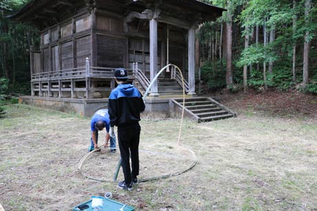  薬師堂で実行委員長の池井さんと新潟大学地域交流サークル学生が竹アートを制作
