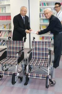 家具のまるやまの丸山社長(ひだり)からつばめ福祉会の岡田理事長に車いすの目録を手渡す
