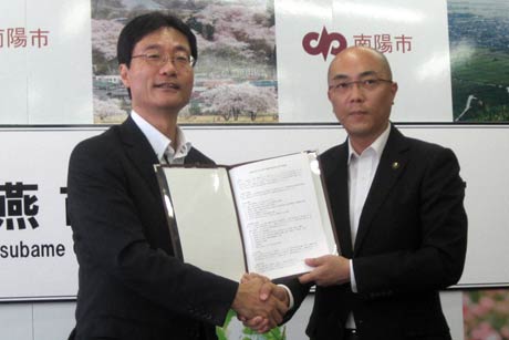 相互応援協定を締結して握手する鈴木燕市長(左)と白岩南陽市長（燕市提供写真）