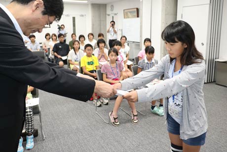  広報「つばめ」子ども版を製作する子ども記者19人に任命書を手渡す鈴木市長