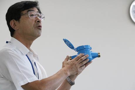水道メーターの口径の違いを説明をする水道局職員